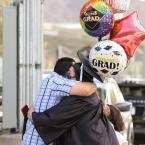 Moorpark College Graduate holding celebratory balloons and h