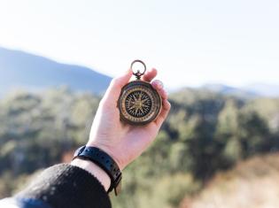 Stock photo of a hand holding a compass