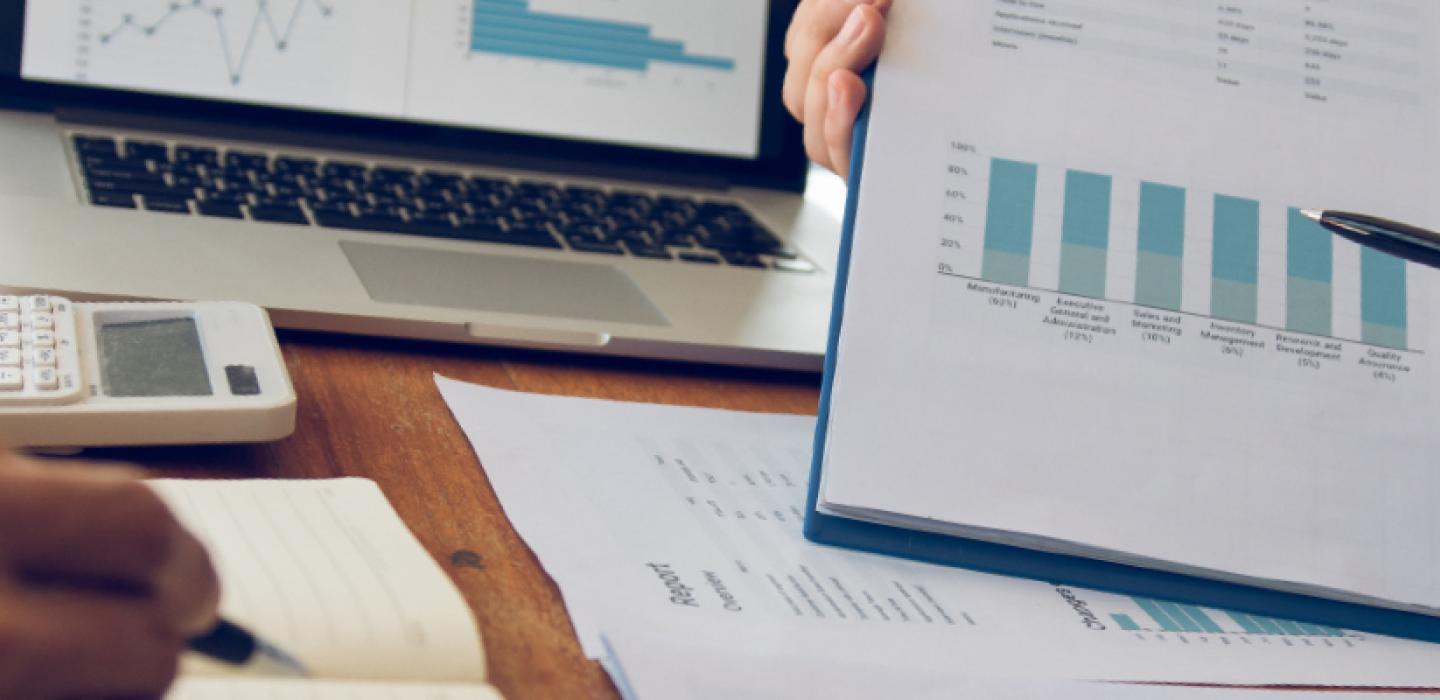 A person presenting financial charts on a clipboard.