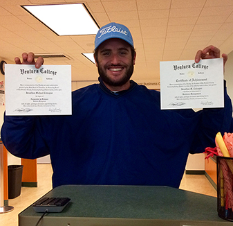 Photo of a student showing diplomas