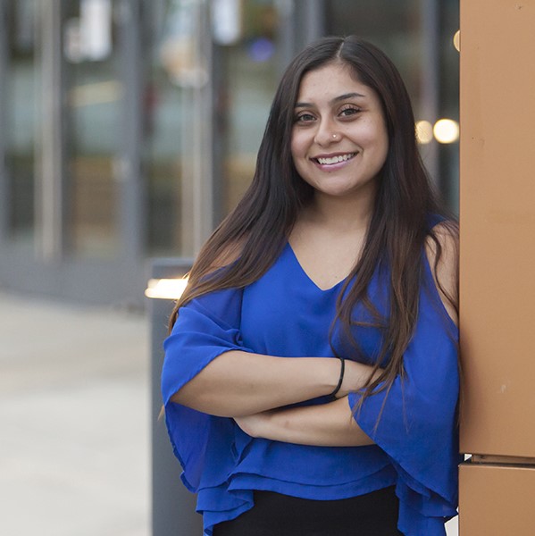 student stands outside ASC building