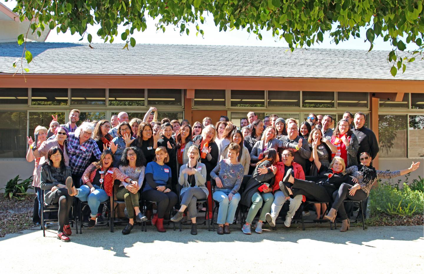 Group photo of VC employees in the Wright Event Center patio on a sunny day and being silly for the photographer.