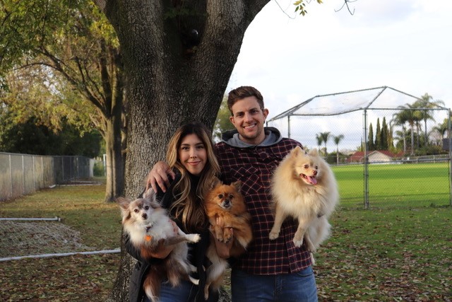Brandon D'Amico standing with his wife and furbabies