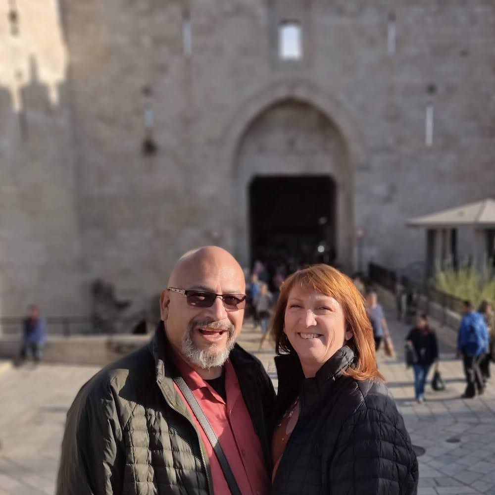 Cathy Bojorquez and Husband posing in front of building while traveling