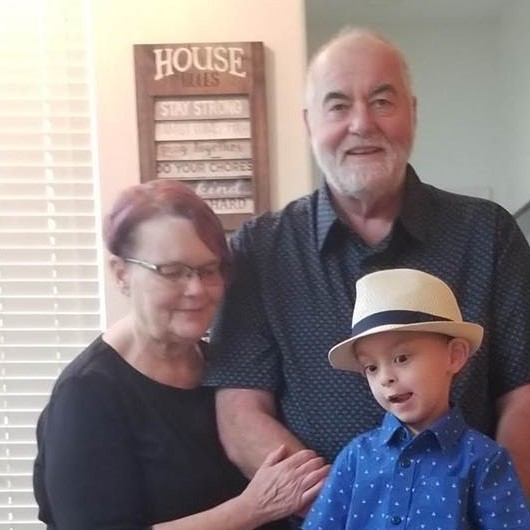 Jeanine Day standing with her husband and grandson.