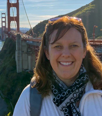 Ann Nelson standing in front of the Golden Gate Bridge