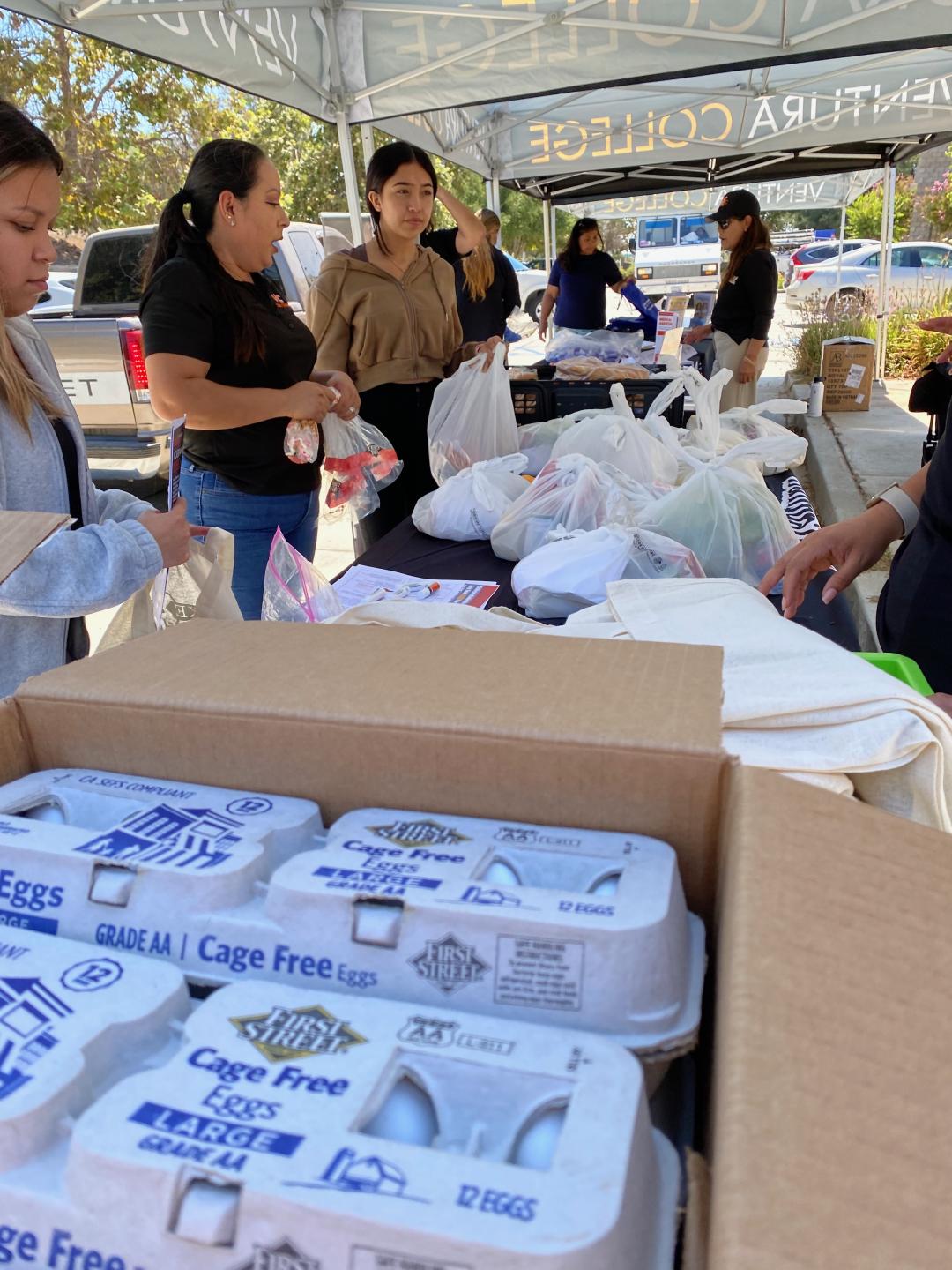 Students receiving free groceries such as eggs, bread and dry goods.