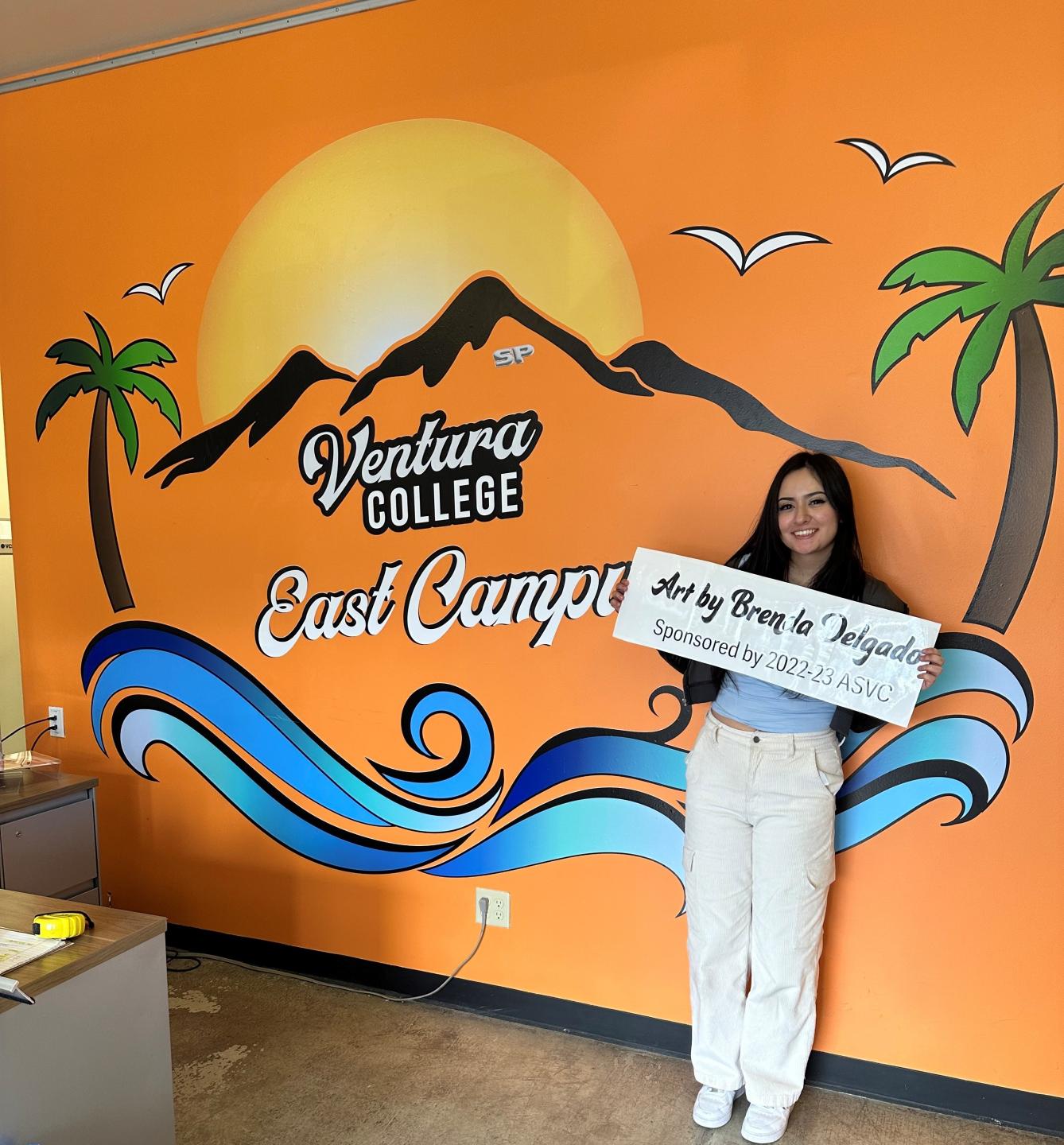 Wall decal of Ventura College East Campus with artist posing 
