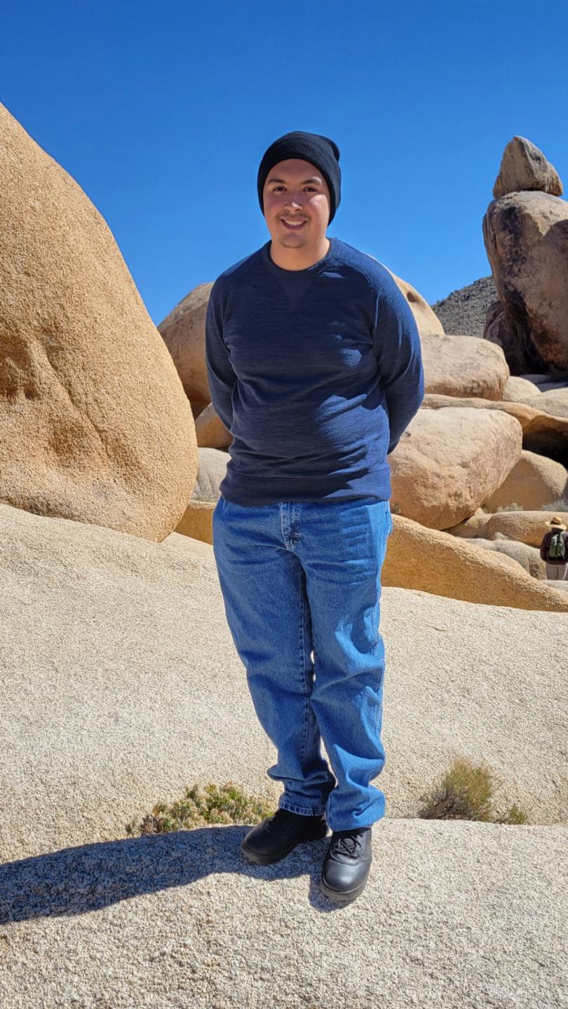 Isaac Rodriguez poses in front of a rock structure