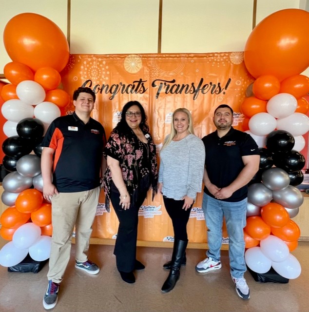 UniversityTransfer Center Staff standing in front of center backdrop with balloon columns on either side