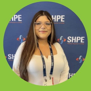 STEM Student in front of SHPE Logo wall