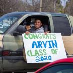 Drive thru graduation at Oxnard College, student holding a s