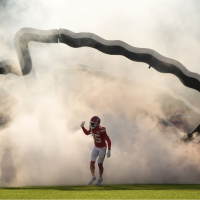 Kansas City Chiefs player wearing number 35 runs onto the field through a smoke-filled tunnel during pregame introductions at Arrowhead Stadium