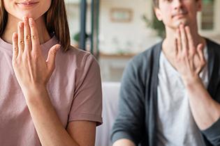Front view of couple communicating with sign language.