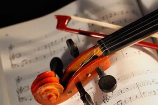 A violin and bow laying on a sheet of music.