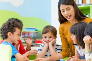 A female instructor talking to young children.