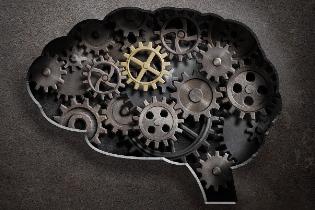 The silhouette of a human brain with cogs and gears filled in.