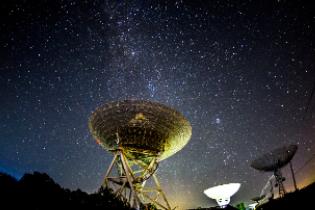 a view of the night sky with satellites in the foreground.