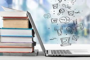 laptop leaning on textbooks