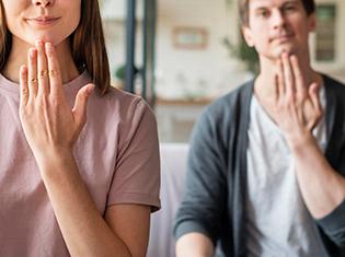 Front view of couple communicating with sign language.