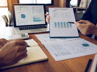 Two people reviewing charts and diagrams on clipboards.