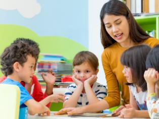 A female instructor talking to young children.