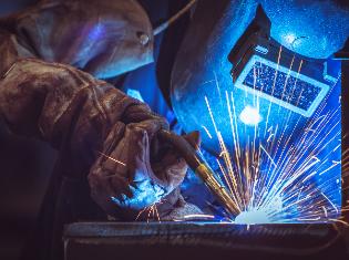 A person welding in full protective gear.