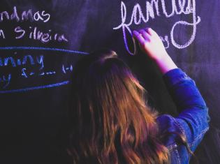 Student writing on blackboard