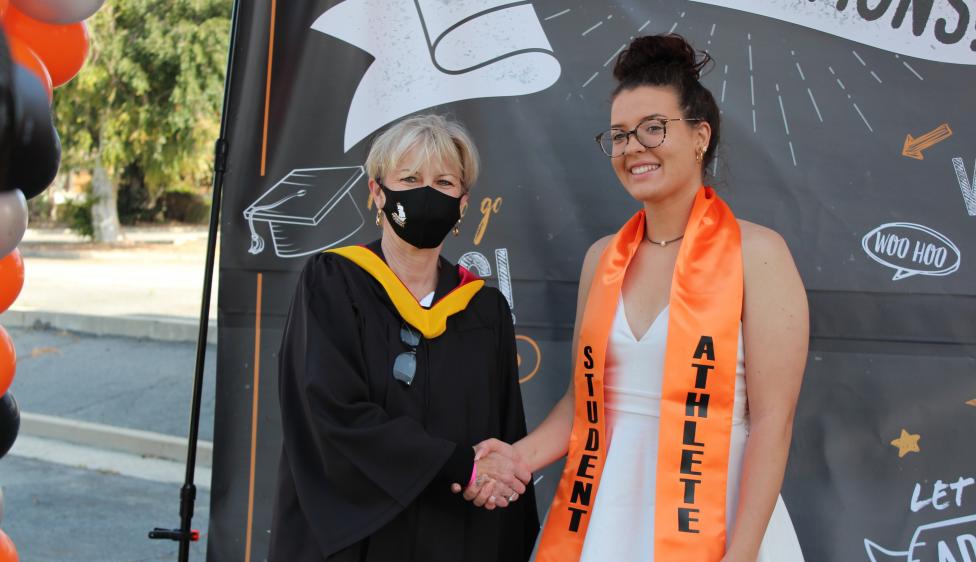 Ventura College Student Athlete Graduate posing with Trustee Dianne McKay