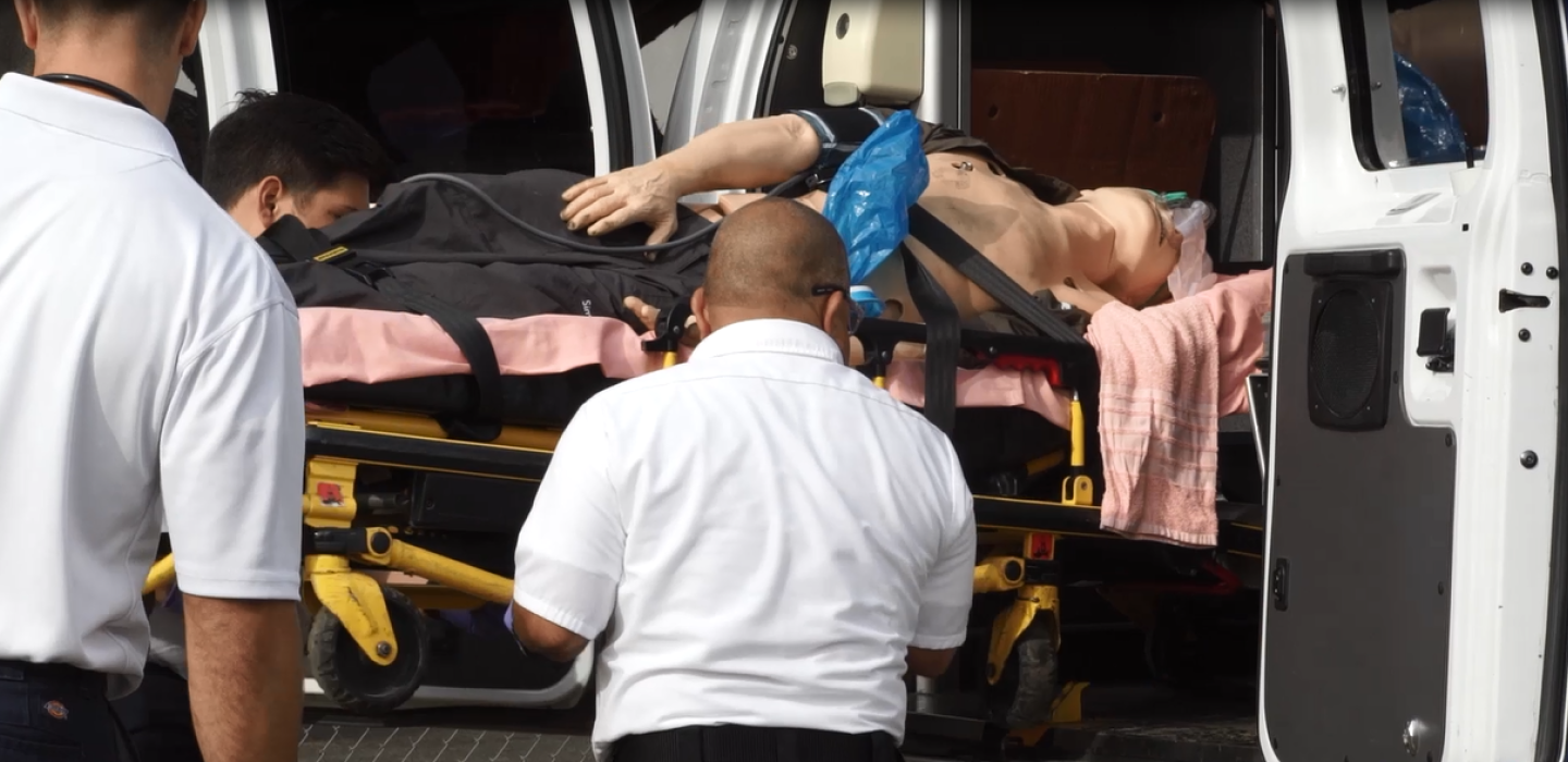 Ventura College EMT Students carry patient on a gurney into an ambulance 