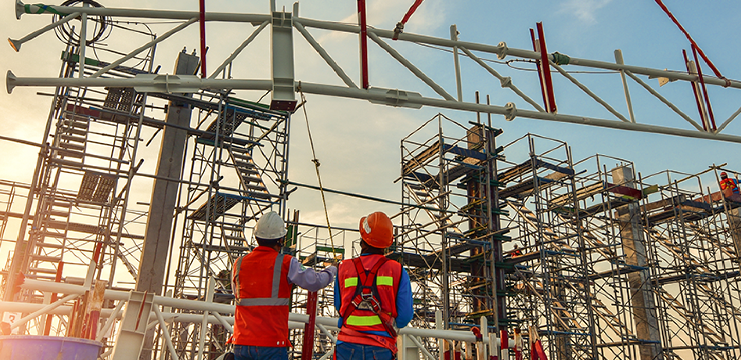 Construction workers supervising a truss installation