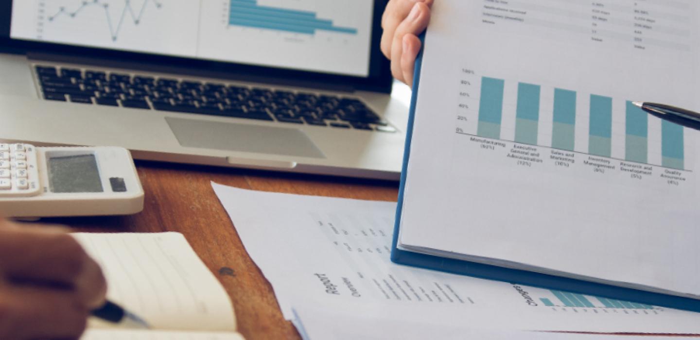 A person presenting financial charts on a clipboard.