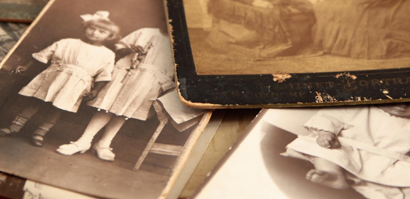 A stack of old sepia toned photographs.