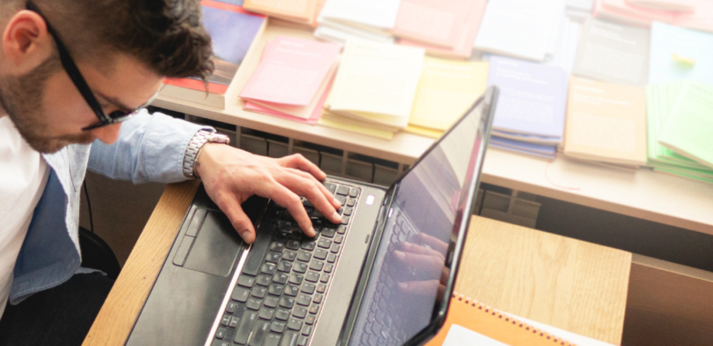 Man wearing glasses working on laptop