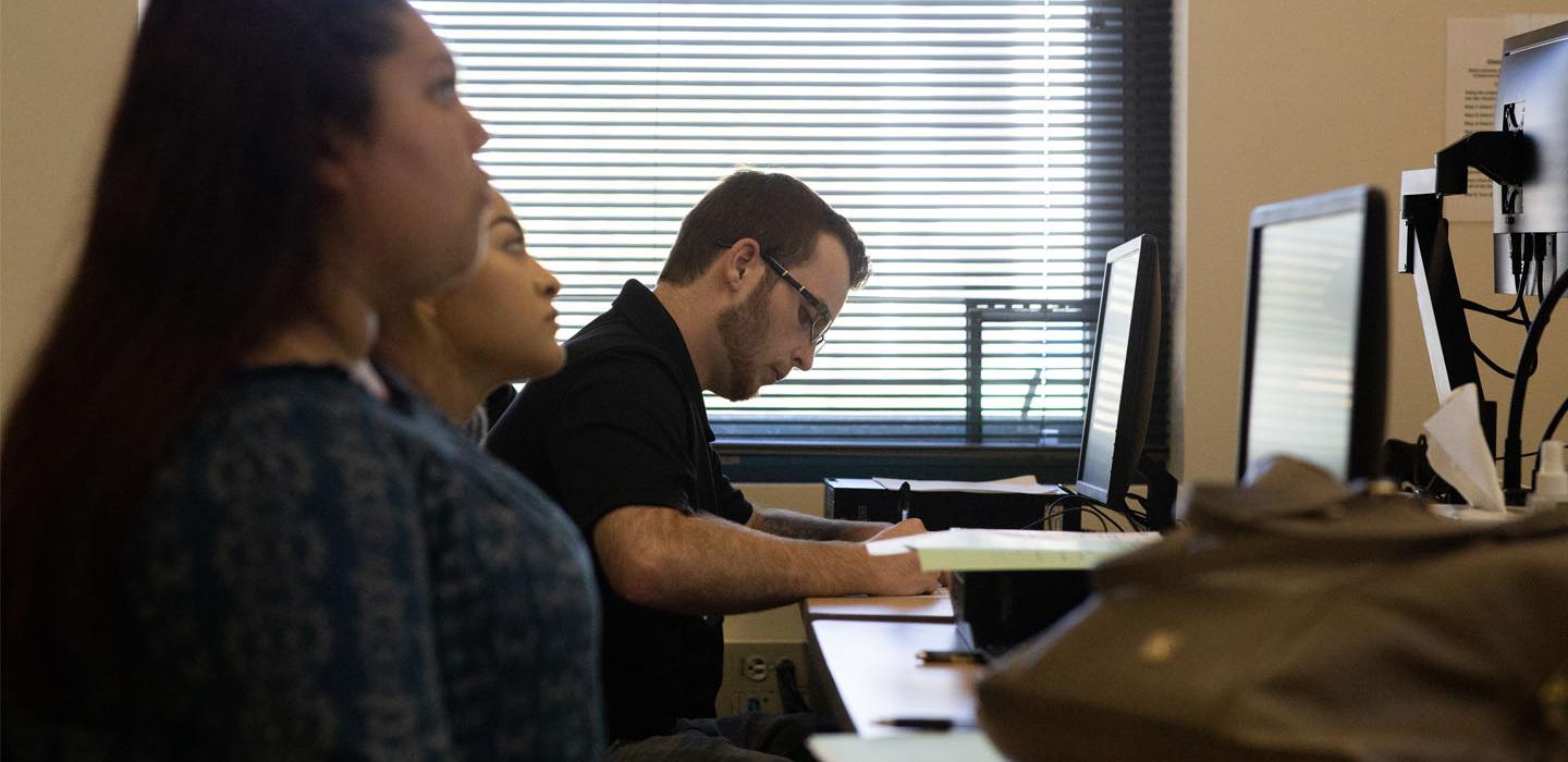 Students at computers in library classroom.