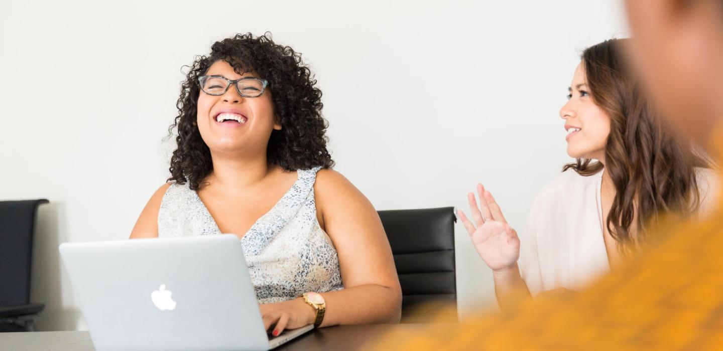 Student with curly hair laughing with peers