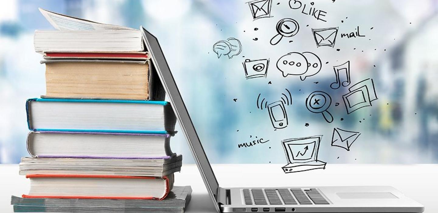 laptop leaning on a stack of textbooks