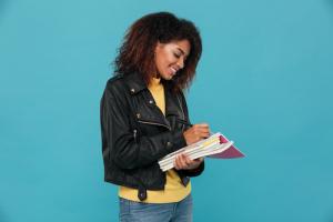 African American woman smiling while highlighting in a textb African American woman smiling while highlighting in a textb