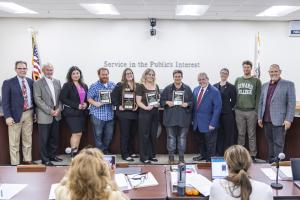 Classified Employee of the Year nominees stand holding plaqu