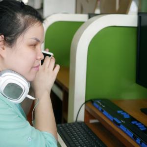 Visually impaired woman using a screen reader and head phone