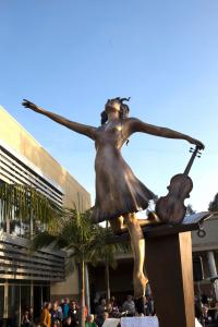 Bronze statue of a girl holding a violin.